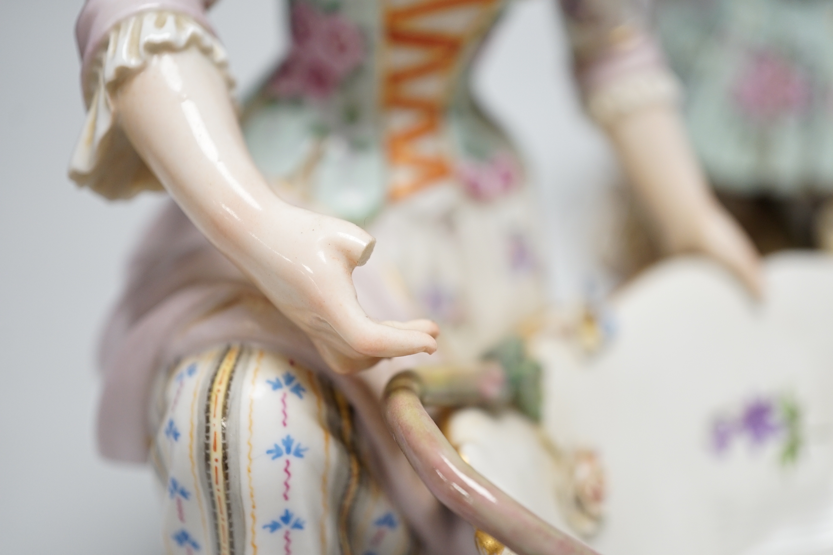 A large pair of Meissen salts in the form of a seated man and a woman in 18th century dress (a.f.), 21cm high